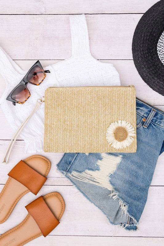 Daisy Wristlet ClutchDaisy Wristlet ClutchWoven Exterior DetailMeasurement 10.5" x 7.25"Removable Vegan Leather WristletPolyester LiningOpen InteriorExterior Material: StrawDaisy Embelli