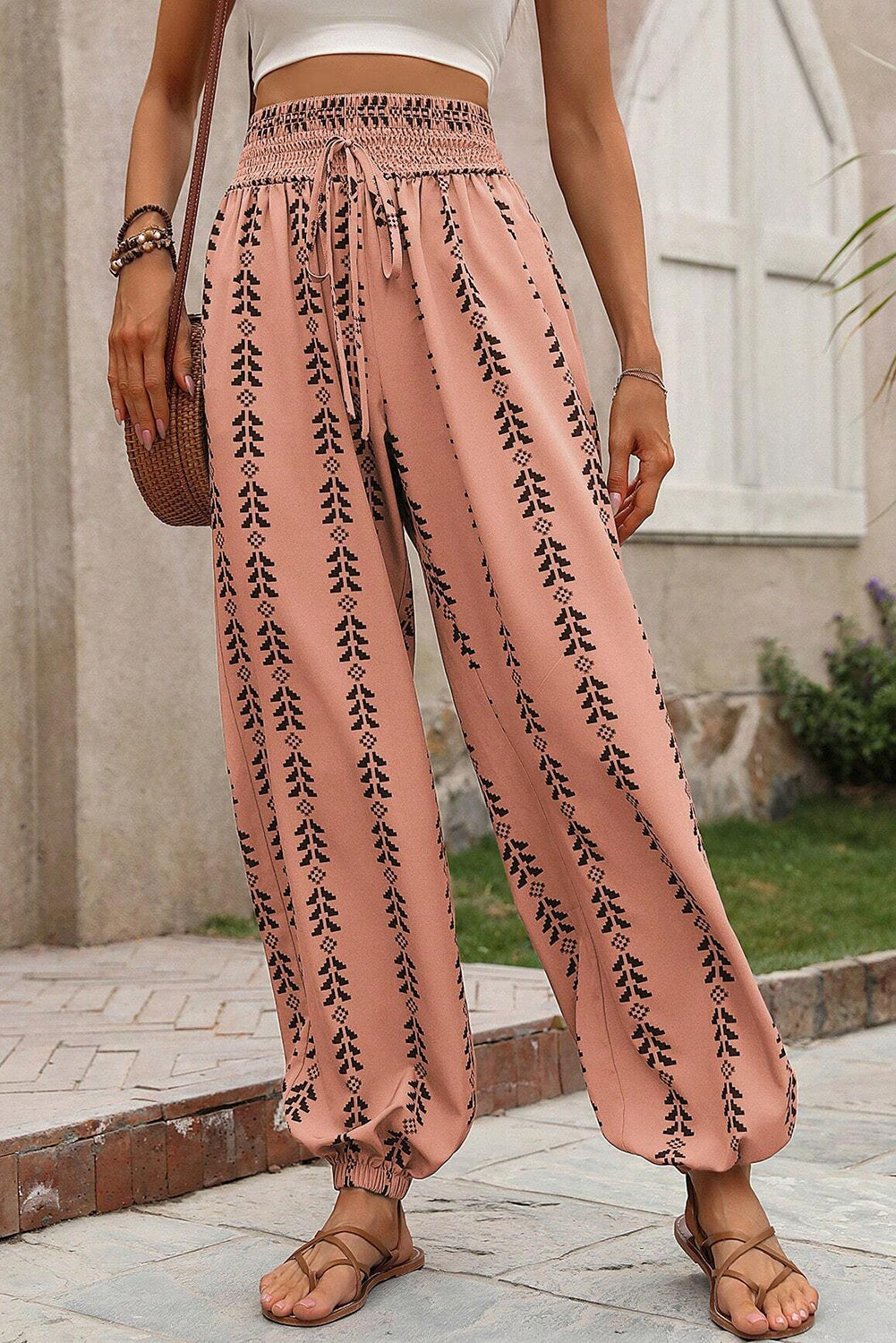 Orange Stripe Geometric Print Smocked Drawstring Pants• This pants feature a boho-chic design that combines geometric patterns and vibrant stripes for a trendy look.
• Crafted with a comfortable smocked waist and adjus