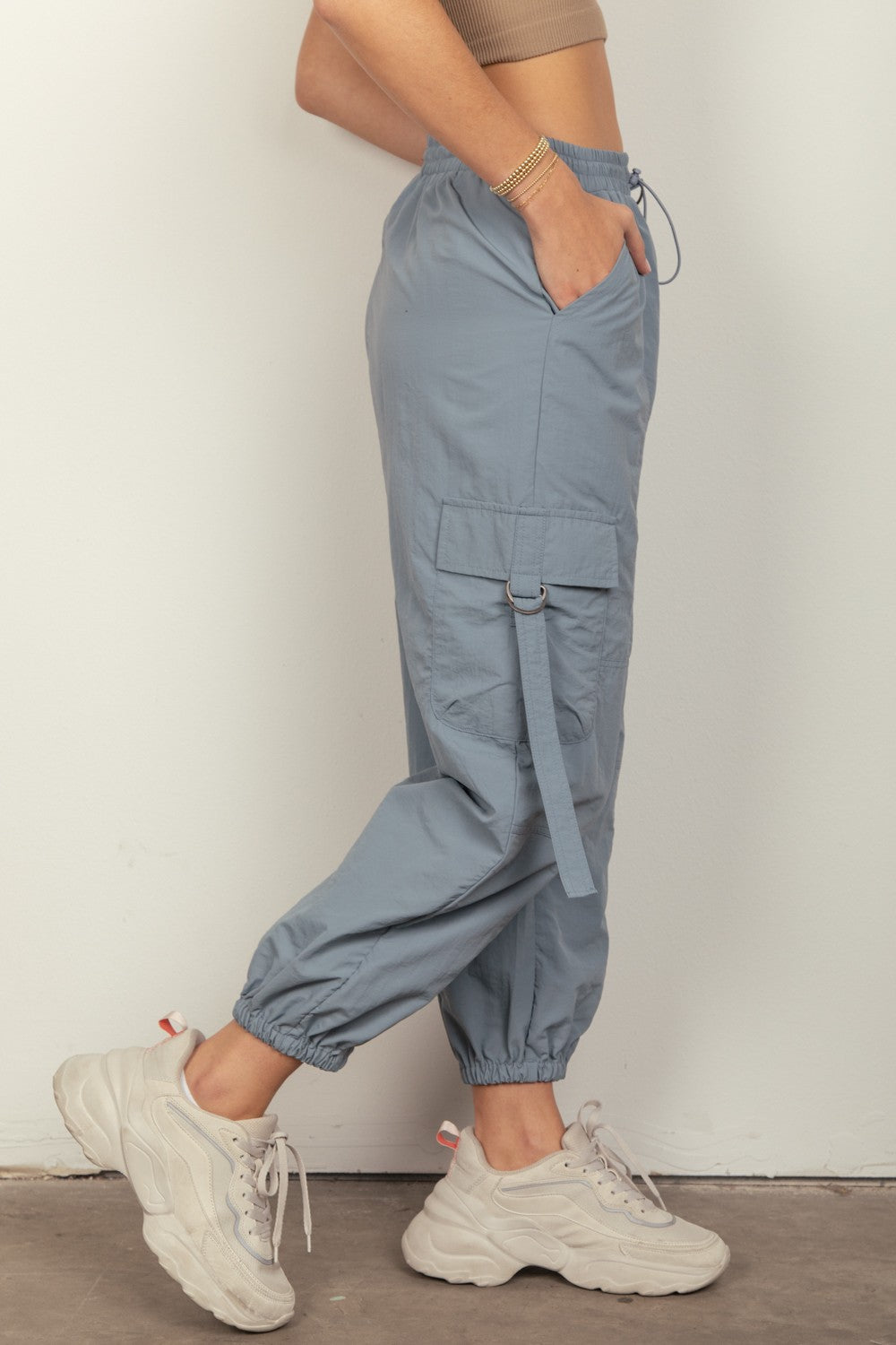 VERY J Elastic Waist Woven Cargo PantsStay on-trend with these Y2K-inspired elastic waist solid woven cargo pants featuring a utility design perfect for everyday wear. The side pockets and D rings add a 