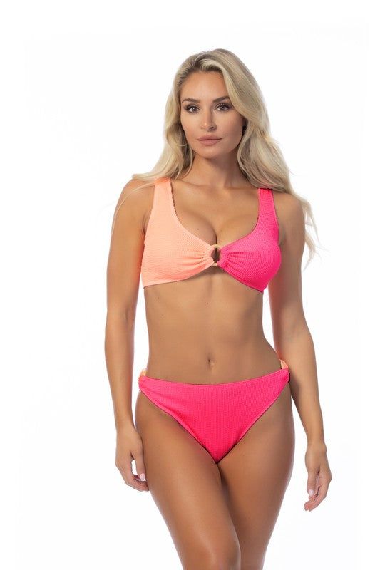 TEXTURED TWO TONE RING ACCENT BIKINI SETTwo-tone color blocking textured bikini set featuring a bandeau top with wooden ring detail and removable pads. Matching with a mid-waist two-tone bottom with wooden