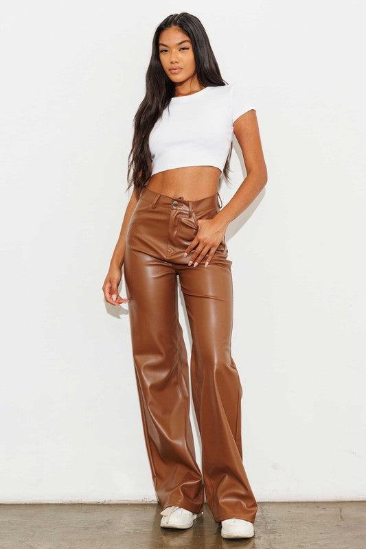 Vegan Leather Wide Leg PantsIndulge in cruelty-free chic with our Vegan Leather Wide Leg Pants. Crafted from high-quality PU, these pants showcase a modern edge with two front and back pockets,