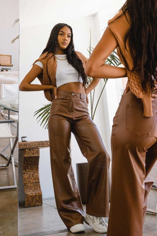 Vegan Leather Wide Leg PantsIndulge in cruelty-free chic with our Vegan Leather Wide Leg Pants. Crafted from high-quality PU, these pants showcase a modern edge with two front and back pockets,