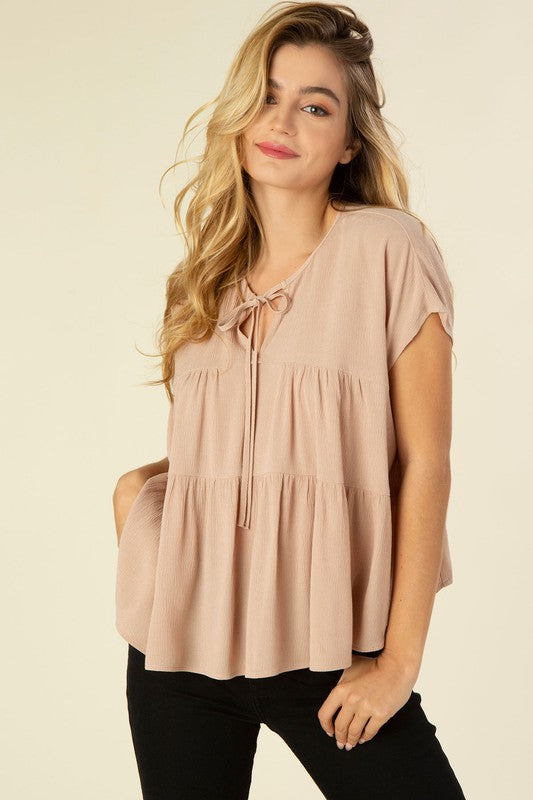 A line tiered blouse- A line tiered blouse- Pattern type : solid- Neck line : round neck when tied, V neck when untied- Sleeve type : dolman short sleeves- Sleeve length : short sleeves