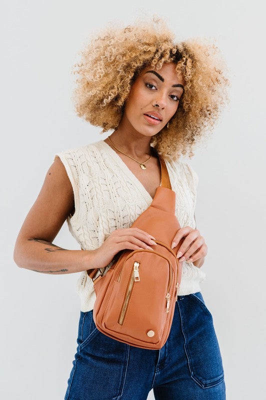 Camry Sling CrossbodyThe Camry Sling Crossbody. This silky-soft vegan leather bag fits everything you need while you're on the go, without being bulky. The front pocket zips for easy pho