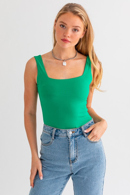 Square Neck Tank BodysuitIntroducing our Square Neck Tank Bodysuit, a versatile and essential addition to your wardrobe. This bodysuit features a classic square neckline that exudes simplici