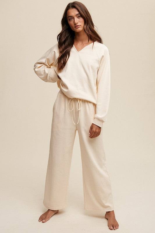 V-neck Sweatshirt and Pants SetThe V-neck Sweatshirt and Pants Set is the epitome of casual comfort with a touch of style. The V-neck sweatshirt offers a relaxed yet flattering fit, perfect for lo