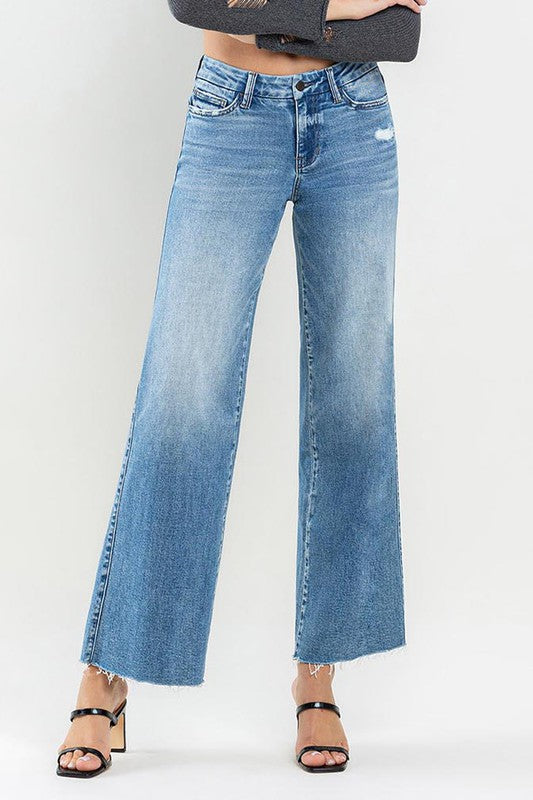 Mid Rise Raw Hem Wide Leg JeansIntroducing our Mid Rise Raw Hem Wide Leg Jeans, a versatile and stylish addition to your denim collection. Crafted from comfortable stretch denim, these jeans offer