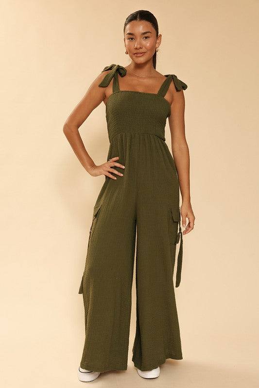 Smocked wide leg cargo jumpsuit*Exclusive In-House Design*-Smocked bodice-Self tie straps-Cargo pockets with d-ring detail-Wide legs-All original designMade In: China