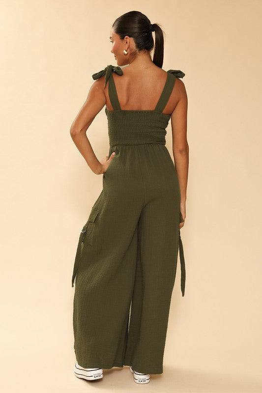 Smocked wide leg cargo jumpsuit*Exclusive In-House Design*-Smocked bodice-Self tie straps-Cargo pockets with d-ring detail-Wide legs-All original designMade In: China