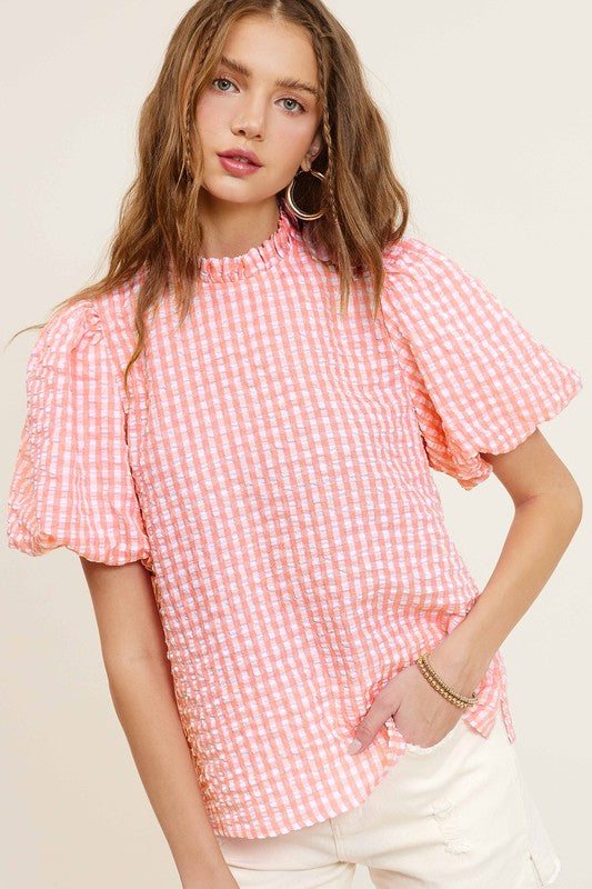 Gingham Check Print Puff Sleeve TopThe Gingham Check Print Puff Sleeve Top exudes femininity and charm with its playful design and swingy silhouette. Crafted from a lightweight and textured gingham ch