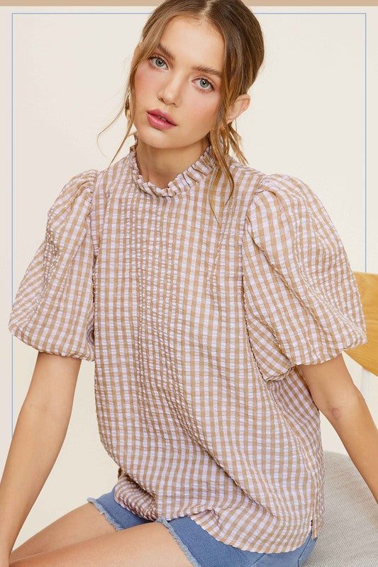 Gingham Check Print Puff Sleeve TopThe Gingham Check Print Puff Sleeve Top exudes femininity and charm with its playful design and swingy silhouette. Crafted from a lightweight and textured gingham ch