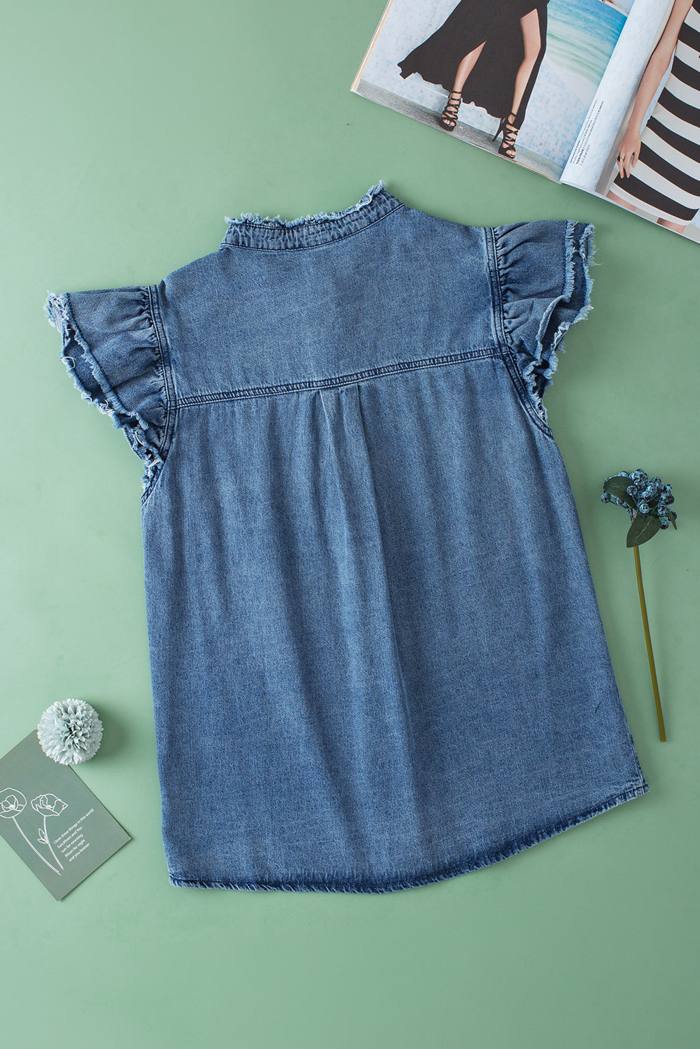 Beau Blue Button Front Ruffled Flutter Frayed Denim TopMaterial:100%Cotton



		The ruffled flutter sleeves create a playful and flirty look, adding movement and charm to the overall design.
	
	
		The frayed detaili