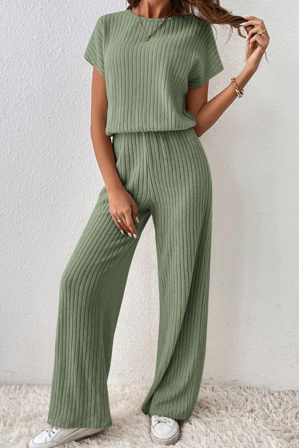 Grass Green Solid Color Ribbed Short Sleeve Wide Leg JumpsuitMaterial:85%Polyester+10%Viscose+5%Elastane



		The jumpsuit is a versatile and trendy one-piece outfit, featuring a solid color design that offers a sleek and mi