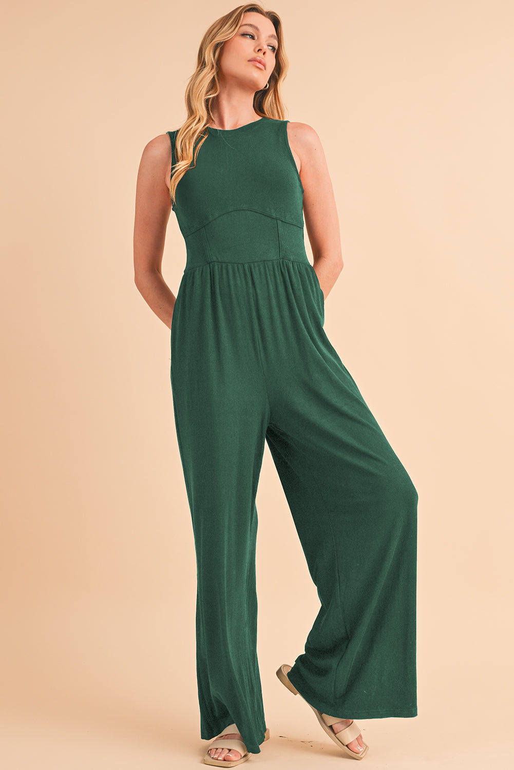 Blackish Green Sleeveless High Waist Wide Leg JumpsuitMaterial:93%Viscose+7%Elastane



		The jumpsuit features a sleeveless design, meaning it does not have sleeves and exposes the arms. 
	
	
		The jumpsuit has a 