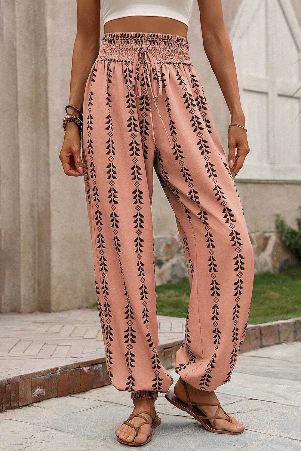 Orange Stripe Geometric Print Smocked Drawstring Pants• This pants feature a boho-chic design that combines geometric patterns and vibrant stripes for a trendy look.
• Crafted with a comfortable smocked waist and adjus