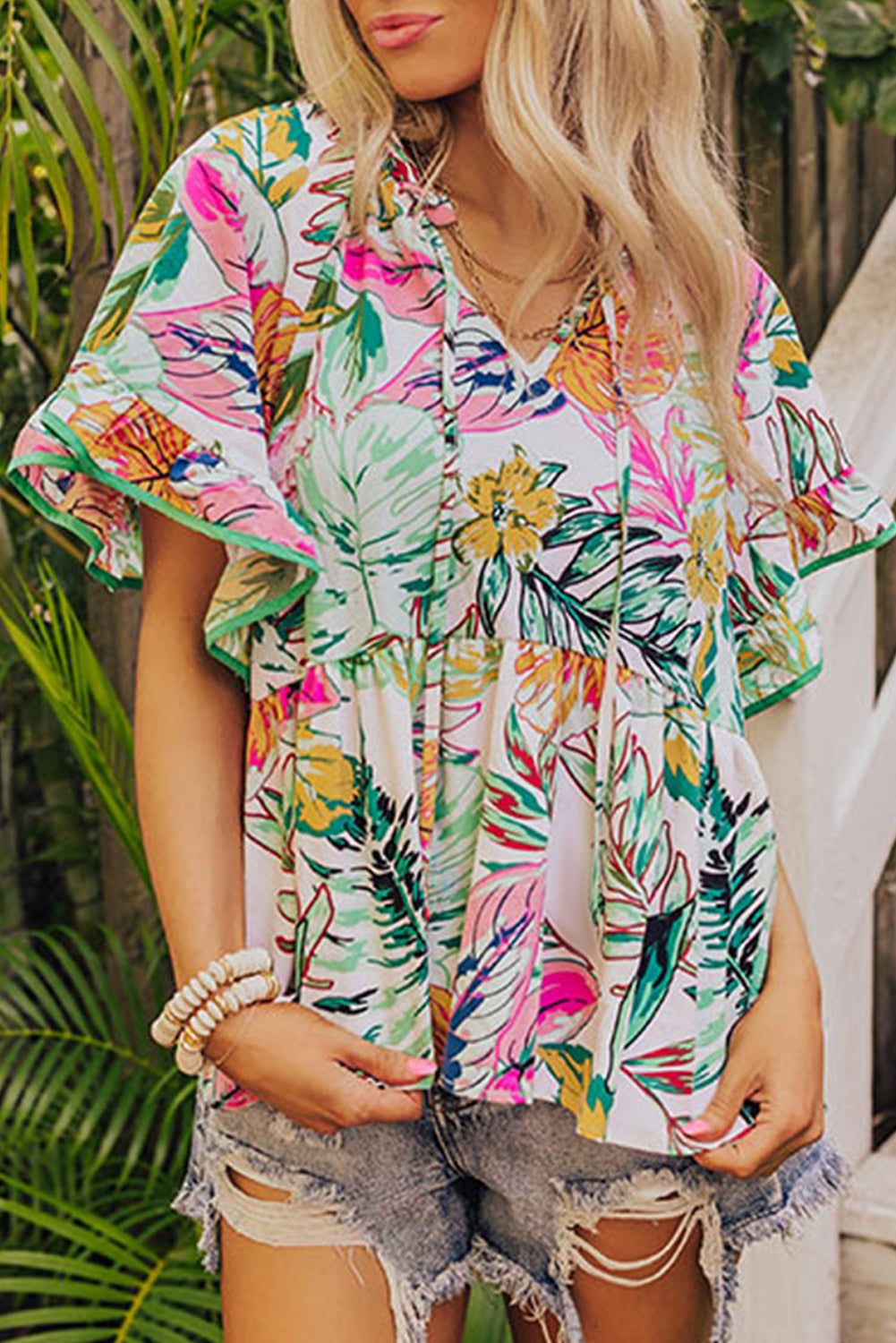 White Tropical Plant Print Tie Neck Ruffle BlouseMaterial:100%Cotton

• Embrace a touch of Boho chic with this blouse, exuding elegance and charm with its delicate floral pattern.
• Elevate your style with the gr