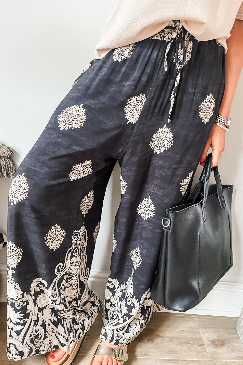 Black Bohemian Print Drawstring Waist Wide Leg PantsMaterial:100%Polyester

• Crafted from high-quality fabric, these pants combine comfort with style for a versatile wardrobe staple.
• The bohemian print adds a tou