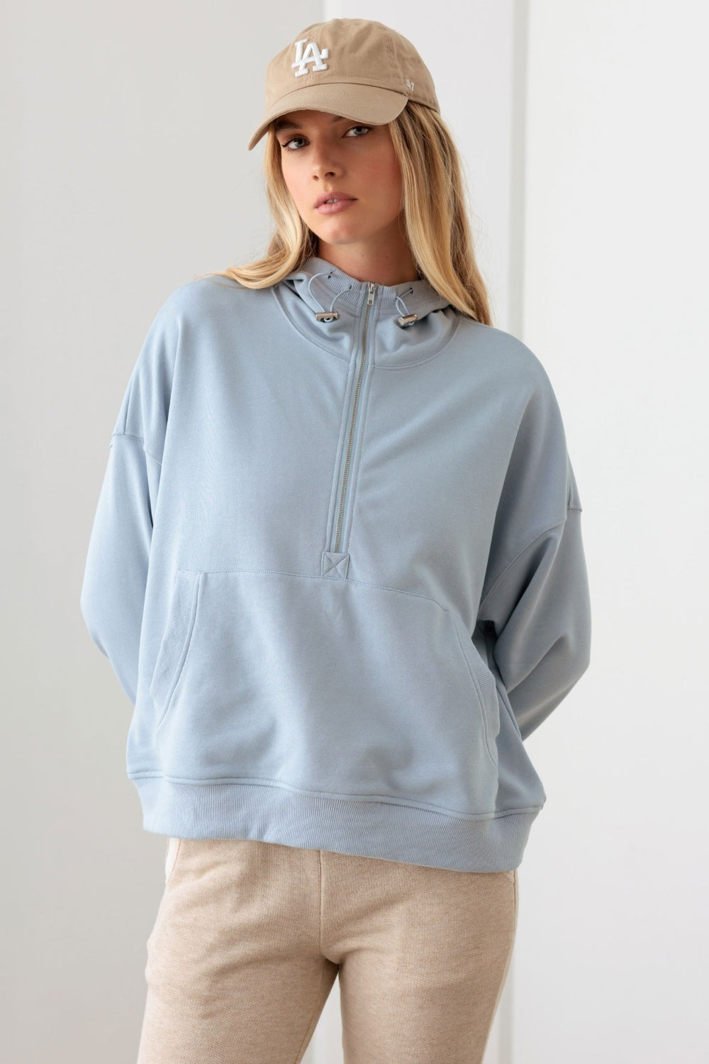 Le Lis Half Zip Drawstring Mock Neck HoodieThe Half Zip Drawstring Mock Neck Hoodie features a solid color design with long sleeves and a front half zipper for easy on and off. The drawstring mock neck adds a