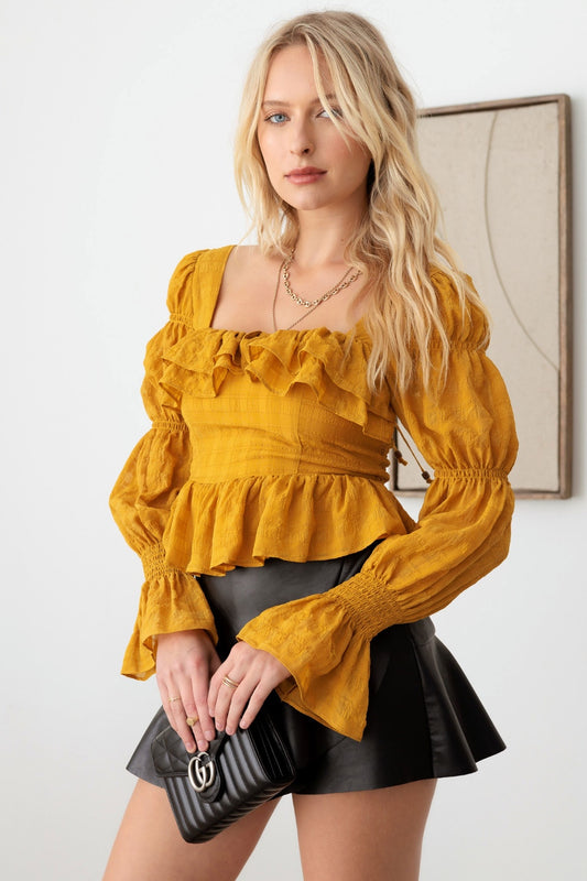 Mustard Seed Boho Shirred Smocked Peplum Long Sleeve TopThis boho shirred smocked peplum long sleeve top is a perfect blend of bohemian and chic style. The shirred detailing adds texture and dimension to the top. The smoc