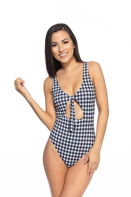 BLACK AND WHITE GINGHAM CUTOUT TIE ONE PIECE SWIMBlack gingham one piece featuring front cut-out detail, self-tie front closure, removable pads, and moderate to full coverage bottom. Super soft microfiber materials