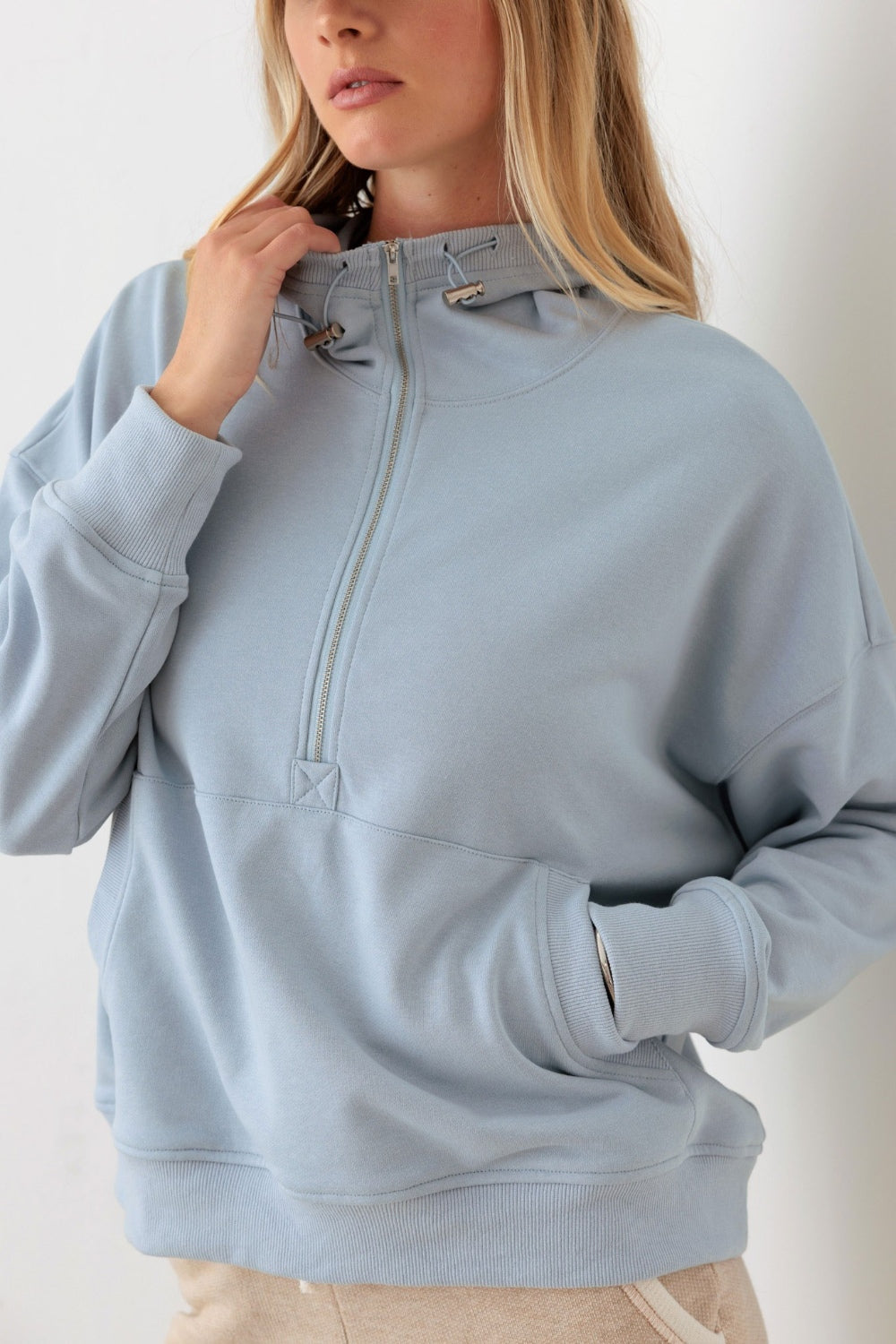 Le Lis Half Zip Drawstring Mock Neck HoodieThe Half Zip Drawstring Mock Neck Hoodie features a solid color design with long sleeves and a front half zipper for easy on and off. The drawstring mock neck adds a