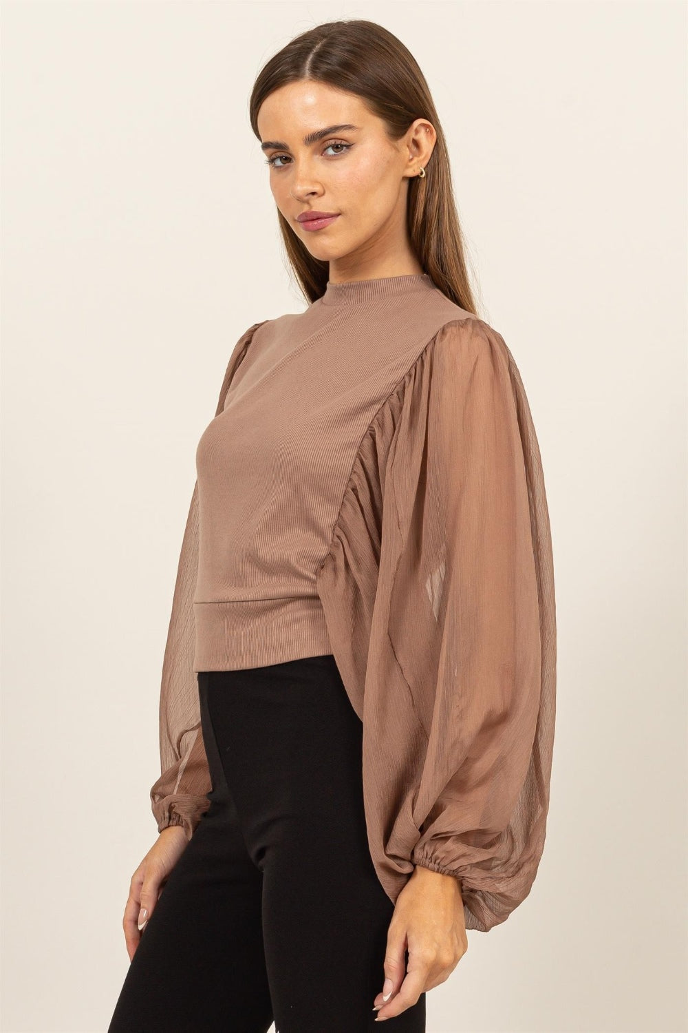 HYFVE Ruched Sheer Long Sleeve Mock Neck BlouseAugment your wardrobe's elegance with this Sheer Sleeve Back Button Blouse. Showcasing delicate sheer sleeves and a sophisticated back button closure, this blouse is