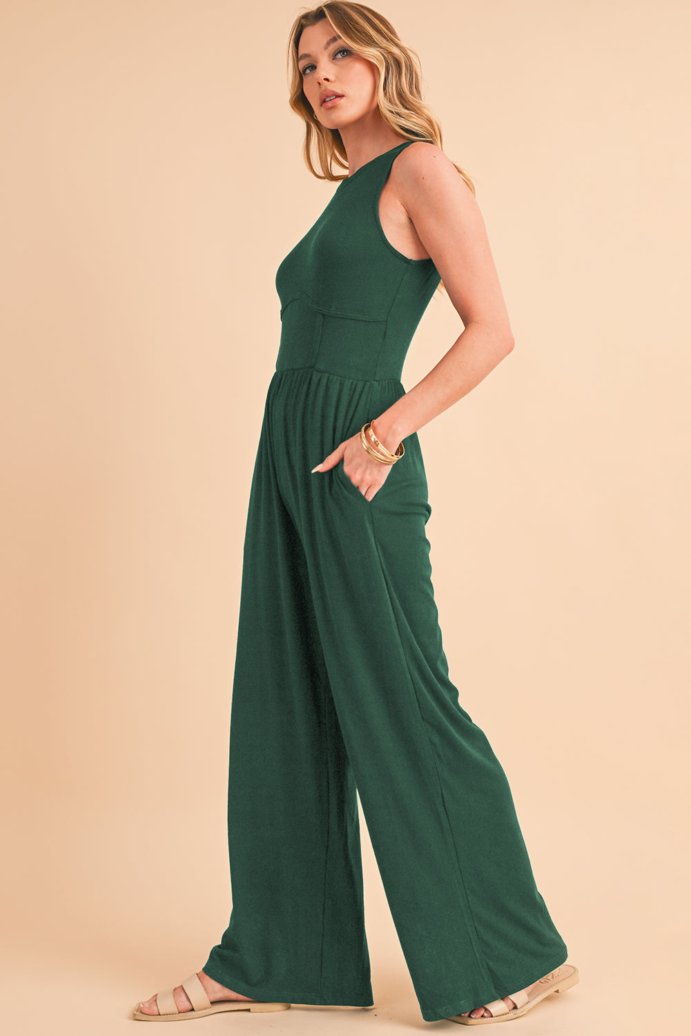 Blackish Green Sleeveless High Waist Wide Leg JumpsuitMaterial:93%Viscose+7%Elastane



		The jumpsuit features a sleeveless design, meaning it does not have sleeves and exposes the arms. 
	
	
		The jumpsuit has a 