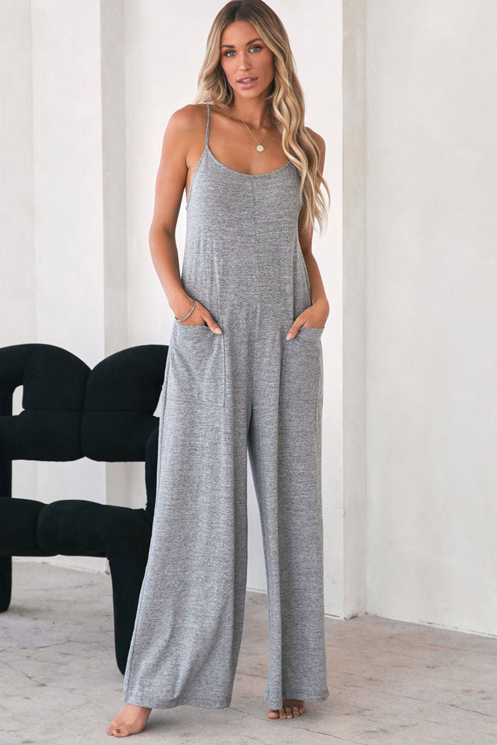 Gray Loose Fit Side Pockets Spaghetti Strap Wide Leg JumpsuitMaterial:65%Polyester+30%Cotton+5%Elastane



		Featuring a loose fit, the wide leg
jumpsuit provides freedom of movement
	
	
		Spaghetti straps highlight wome