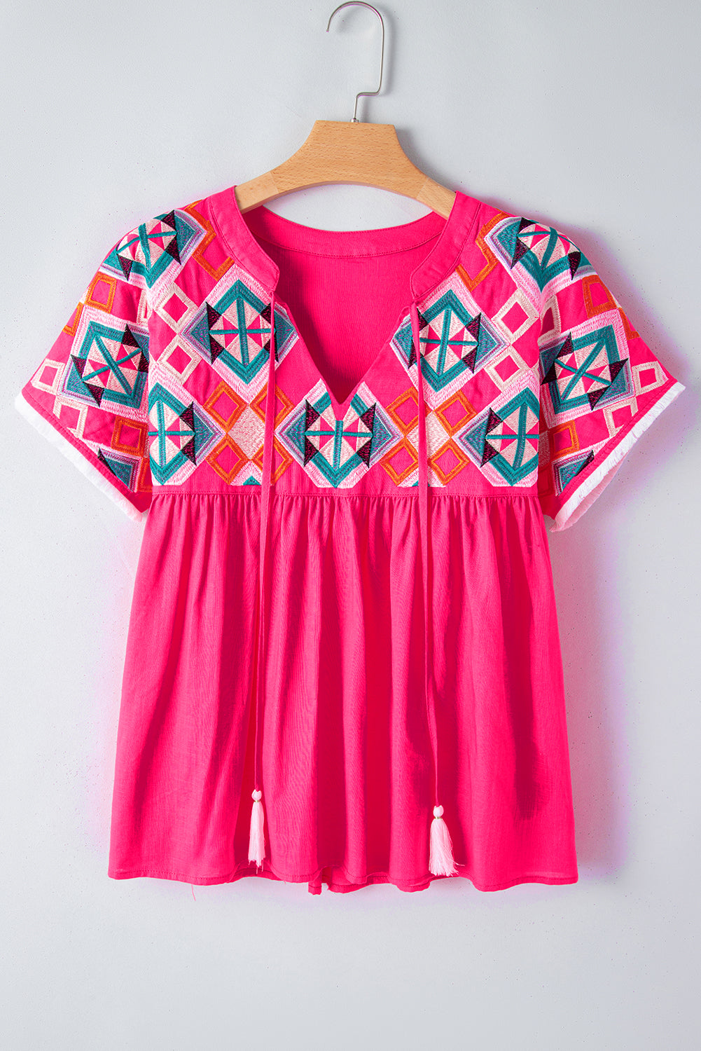 Strawberry Pink Geometric Embroidered Tassel Tie V Neck BlouseMaterial:100%Cotton



		The blouse is a stylish and bohemian-inspired top that combines geometric embroidery with tassel details.
	
	
		This blouse features a 