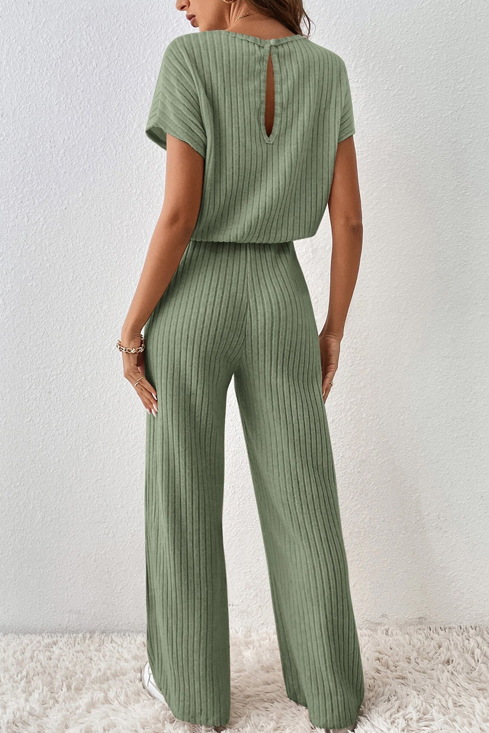 Grass Green Solid Color Ribbed Short Sleeve Wide Leg JumpsuitMaterial:85%Polyester+10%Viscose+5%Elastane



		The jumpsuit is a versatile and trendy one-piece outfit, featuring a solid color design that offers a sleek and mi