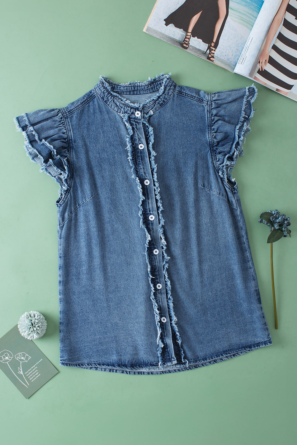 Beau Blue Button Front Ruffled Flutter Frayed Denim TopMaterial:100%Cotton



		The ruffled flutter sleeves create a playful and flirty look, adding movement and charm to the overall design.
	
	
		The frayed detaili