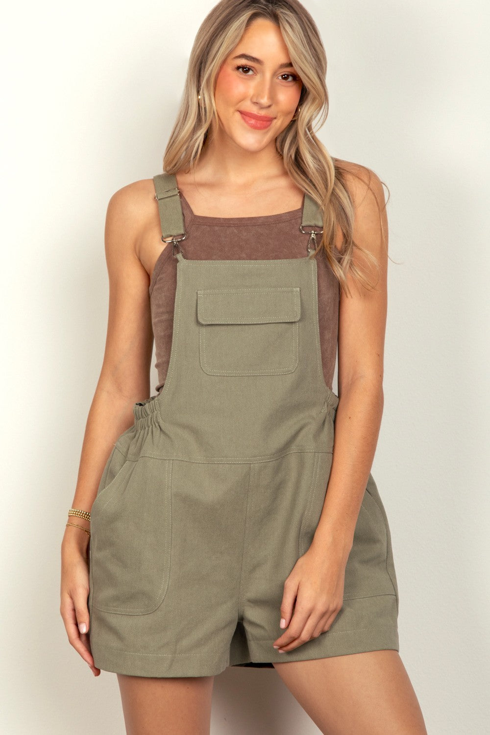 VERY J Adjustable Suspender Overalls with PocketsThe versatile Suspender Solid Woven Casual Overall Romper features front and side pockets for added functionality. The elastic waist ensures a comfortable and adjust