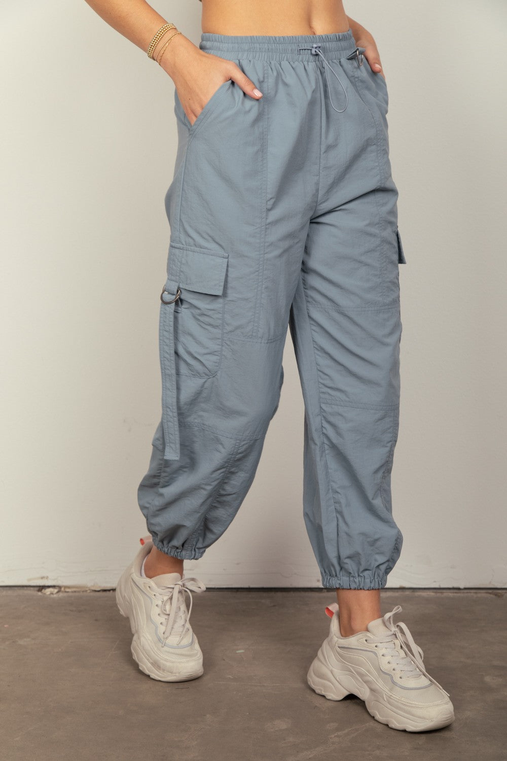 VERY J Elastic Waist Woven Cargo PantsStay on-trend with these Y2K-inspired elastic waist solid woven cargo pants featuring a utility design perfect for everyday wear. The side pockets and D rings add a 