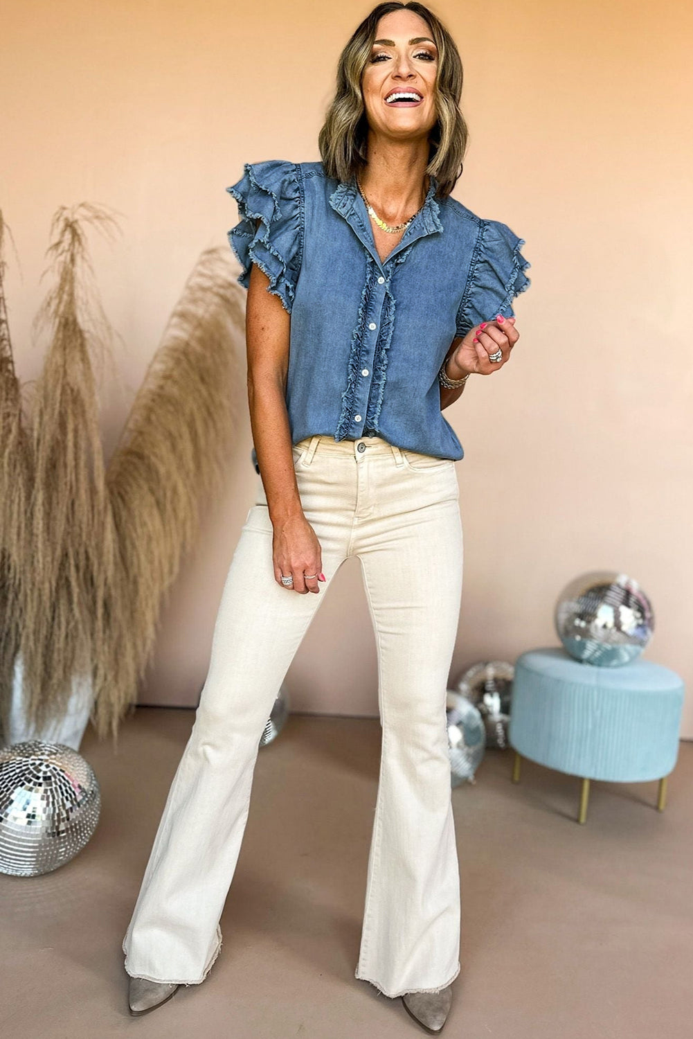 Beau Blue Button Front Ruffled Flutter Frayed Denim TopMaterial:100%Cotton



		The ruffled flutter sleeves create a playful and flirty look, adding movement and charm to the overall design.
	
	
		The frayed detaili